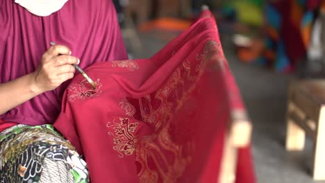 close up, women make batik fabrics in a traditional, flexible way