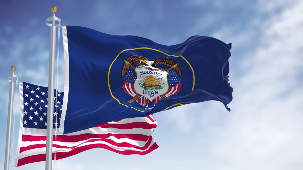 The Utah state flag waving along with the national flag of the United States of America