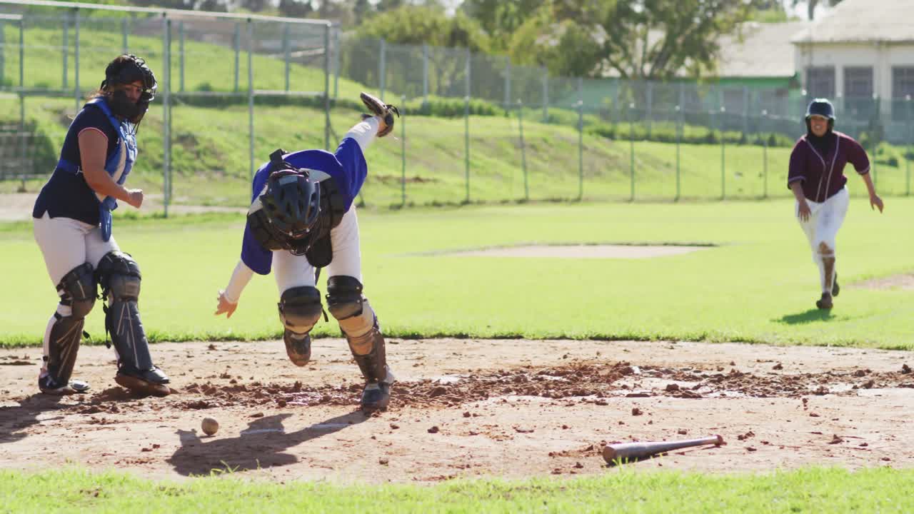 Diverse group of female baseball players, fielder attempting to catch running hitter at base