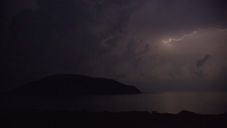 tormenta de verano en el cielo oscuro de la noche con nubes sobre una isla