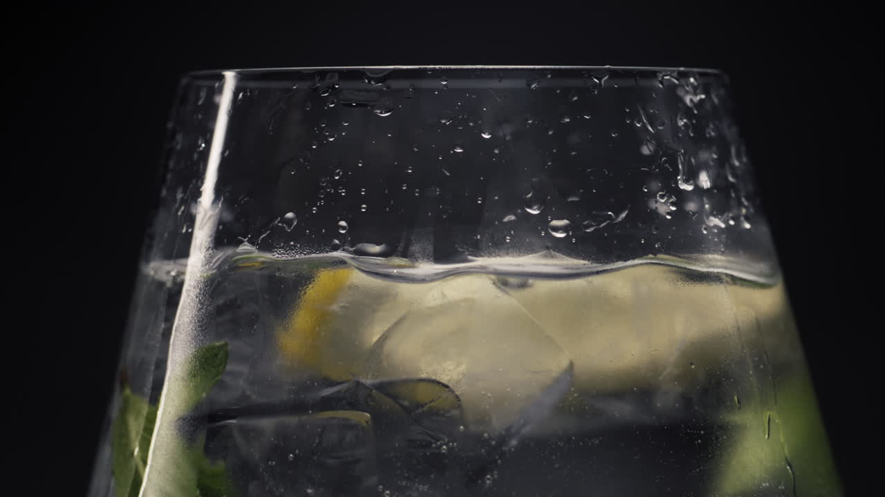 limón caída agua de menta caído de vidrio primer plano. concepto de bebidas refrescantes de verano