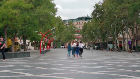 people walking on a city street with trees and buildings