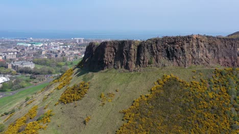 orbit around the crags at arthur's seat, near holyrood parliament, with tourists walking | edinburgh, scotland | 4k at 30 fps