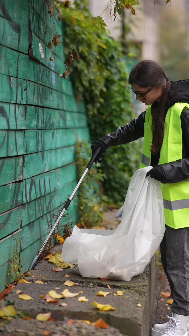 mujer limpiando la basura en la calle