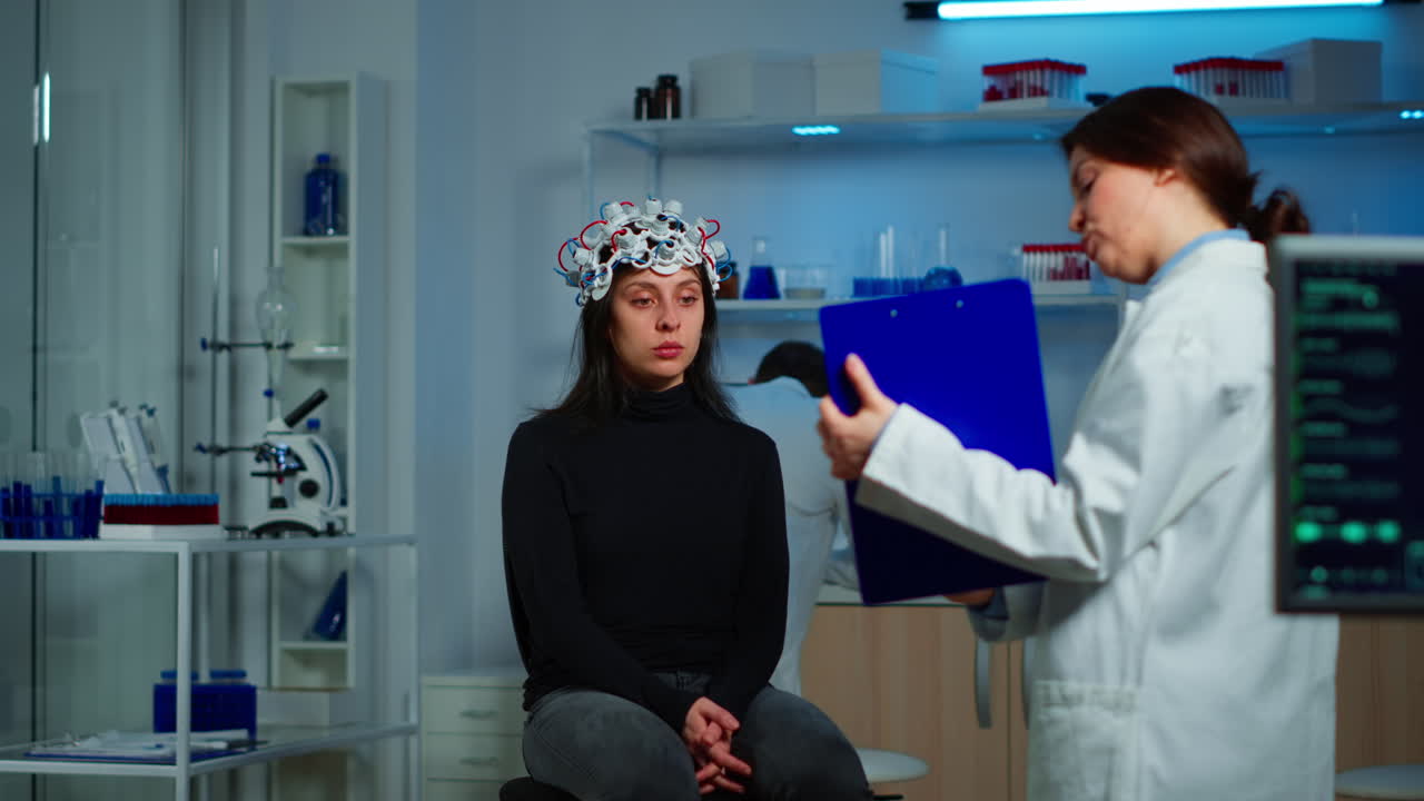 뇌 질환 에 대한 치료법 을 설명 하는 클립보드 를 가리키는 연구원