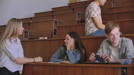 the group of cheerful happy students sitting in a lecture hall before lesson. the group of cheerful students sitting in a lecture hall before lesson.