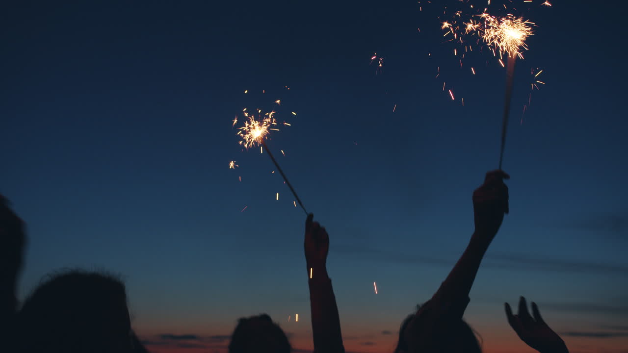 Friends Celebrating at Sunset by the Lake with Sparkler