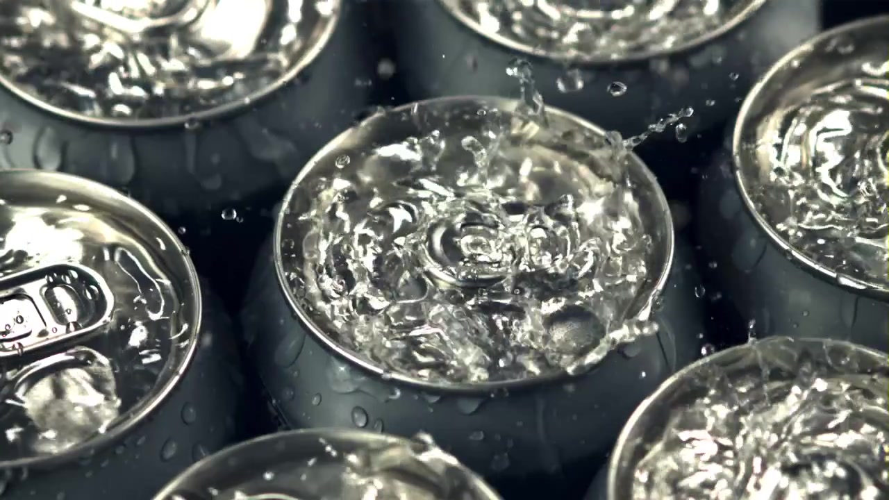 Gocce d'acqua rinfrescanti che schizzano su lattine di alluminio bagnate
