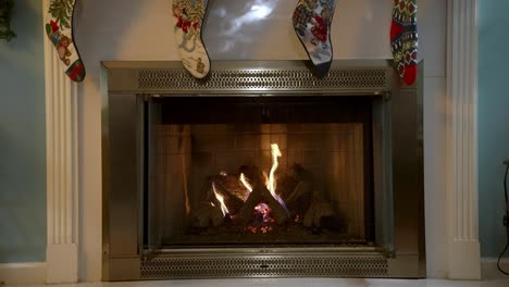 christmas socks hanging above burning warm fireplace in home interior