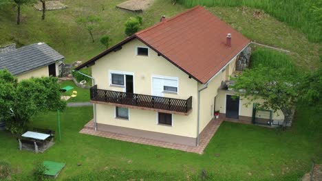 casa familiar con fachada amarilla en medio de la naturaleza verde