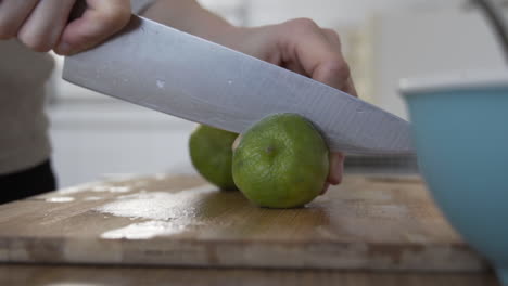 cutting a lime in half, in the kitchen