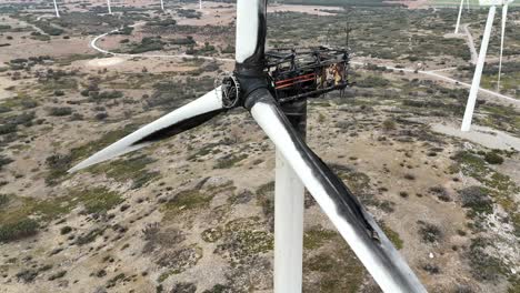 Vista-Aérea-De-Primer-Plano-Medio-De-Una-Turbina-Eólica-Destruida-Por-Un-Incendio-En-Una-Zona-Montañosa-En-España