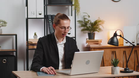 young father businessman with laptop having video call while little daughter disturbs him at work