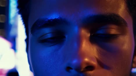 close-up of a man's face with blue lights reflecting in his eyes