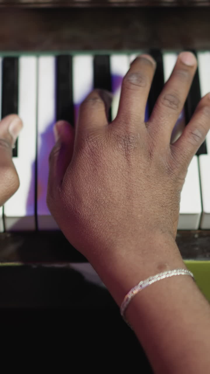 Musician plays composition on piano in class closeup. Black music teacher performs melody on instrument with keyboard indoors. Playing practice