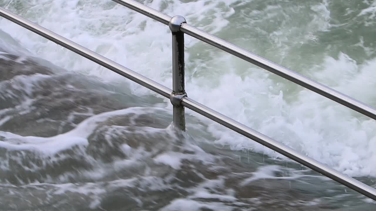 Railings and steps getting covered by a high tide