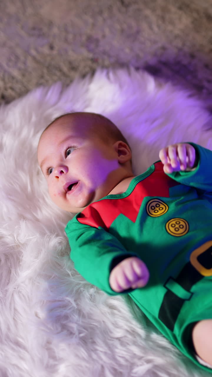 Cute newborn baby in gnome costume lies on a fluffy plaid. Adorable little child at Christmas tree. Vertical video