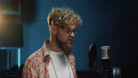 Stylish-Young-Guy-Singer-Singing-In-The-Microphone-In-The-Sound-Studio-While-Recording-His-New-Song