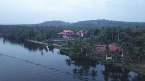 Ascending-Reveal-Shot-Of-Isola-Di-Cocco-,-An-Ayuverdic-Beach-Resort-On-The-Banks-Of-Poovar-River-In-Kerala,-India---aerial-drone