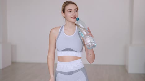 woman drinking water after workout