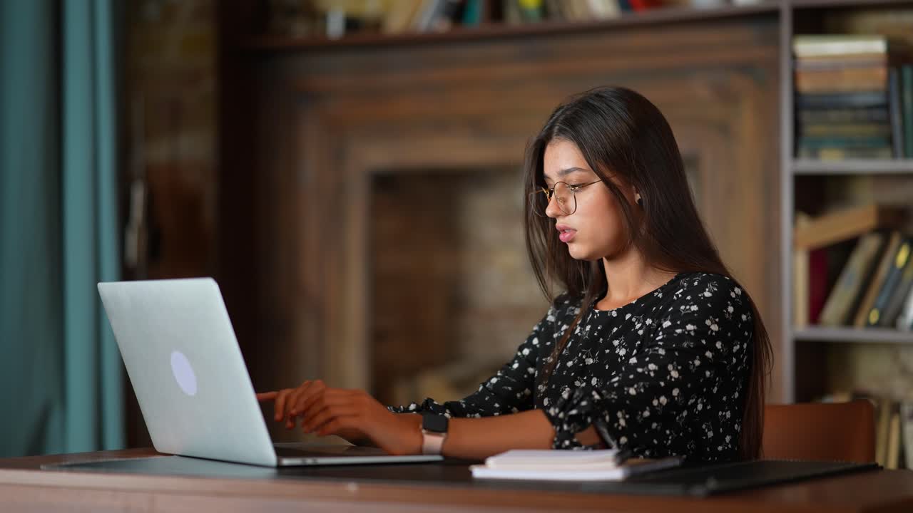 mujer trabajando en una computadora portátil en una biblioteca