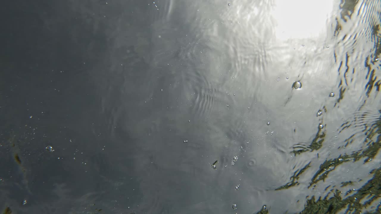 mar tranquilo y transparente con pequeñas piedras salpicadas en un día soleado