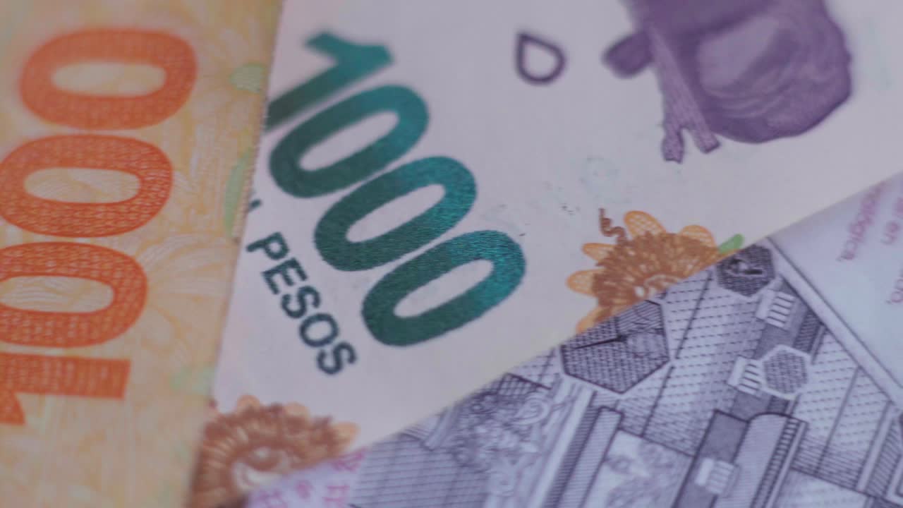 primer plano de billetes argentinos de diferentes denominaciones, desplazándose de izquierda a derecha