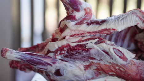 traditional lamb butchering, featuring freshly halved and salted carcass laid out on rustic wooden surface