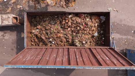 a digger dumps food waste into a huge container, sweden