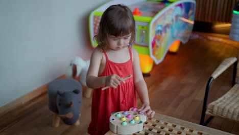 Niña-Preescolar-De-3-Años-Jugando-Un-Juego-De-Pesca-Magnético-De-Madera-Para-Niños-Pequeños,-Aprendiendo-Habilidades-Motoras-Finas-Y-Coordinación-Mano-ojo