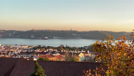aerial dolly of river tagus among pine trees in sunny daytime in lisbon with cristo rei and bridge 25th in background