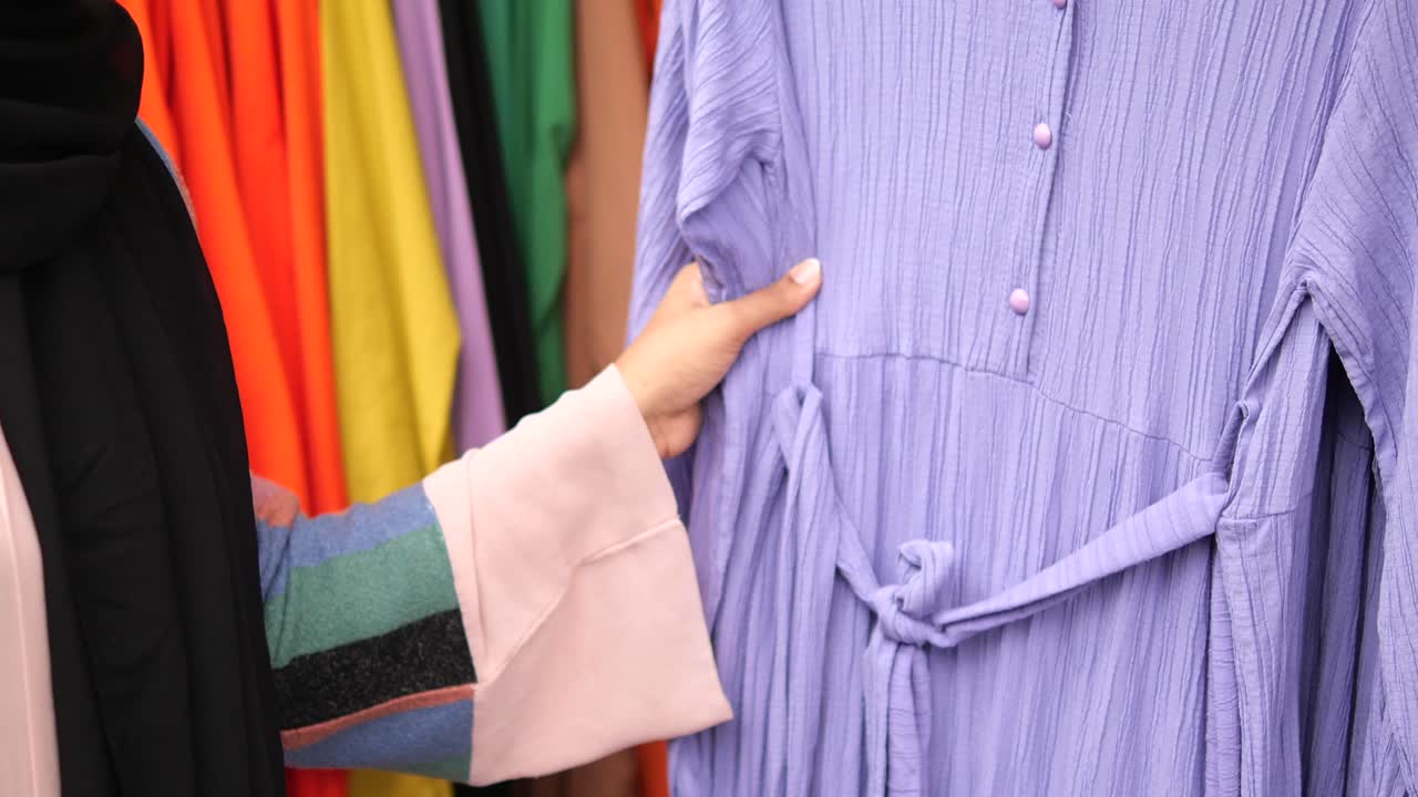 mujer comprando un vestido púrpura en una tienda de ropa