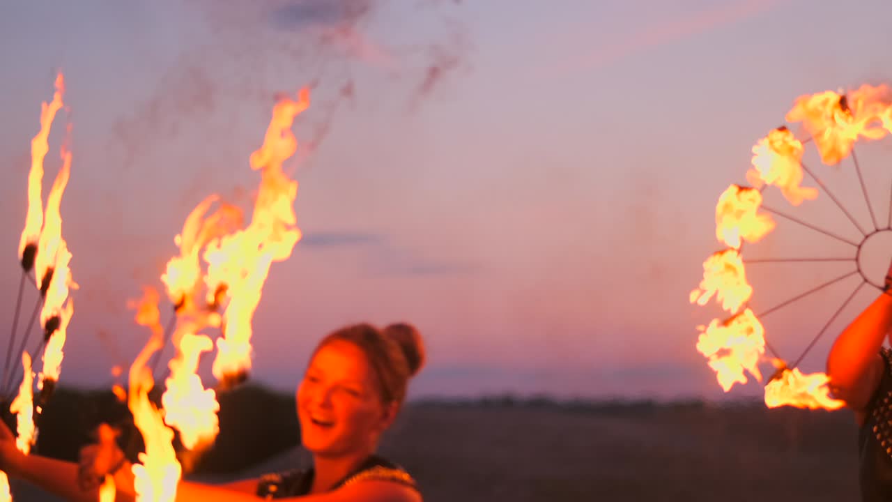 bailarinas profesionales mujeres hacen un espectáculo de fuego y una actuación pirotécnica en el festival con antorchas brillantes en llamas.