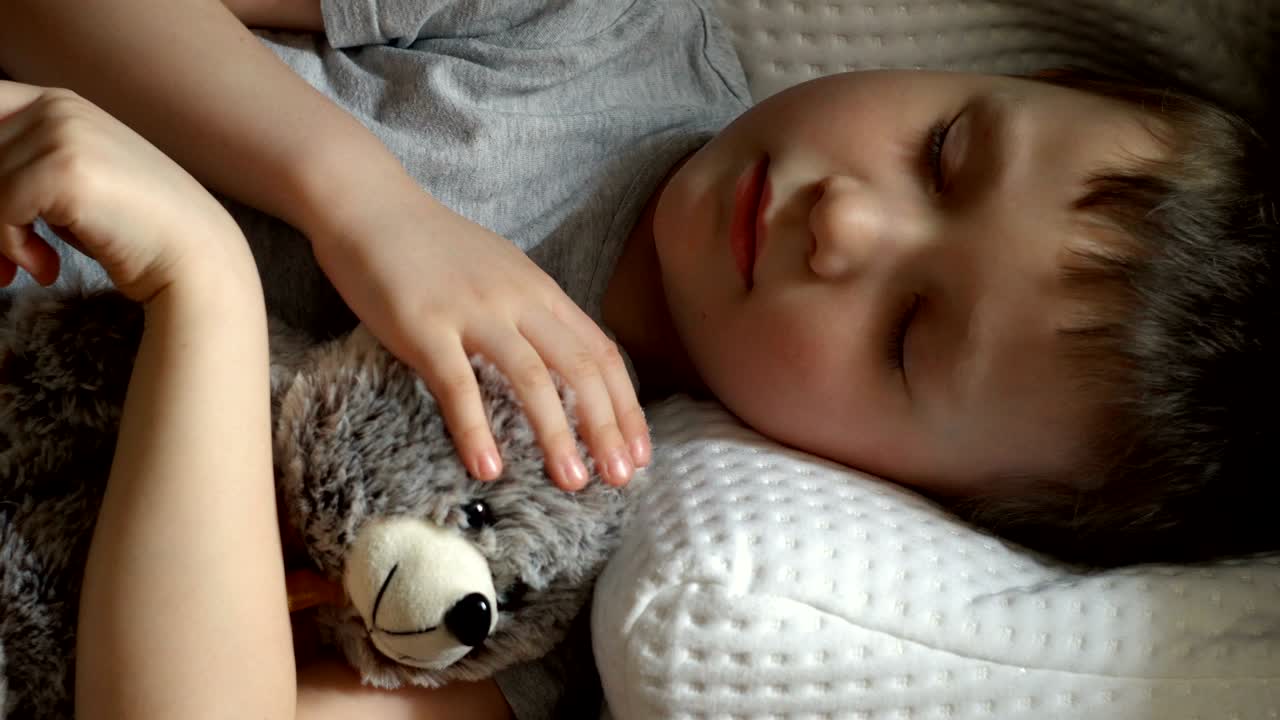 아이는 잠을 자고 장난감 을 만져요.