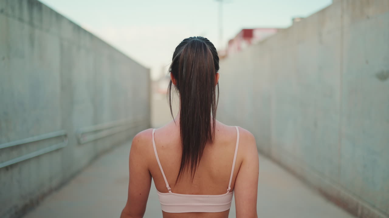 Woman walking outdoors in sports bra