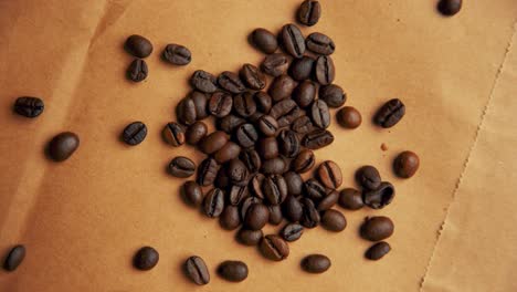 Coffee-beans-on-old-paper-rotating-4K-video-from-top