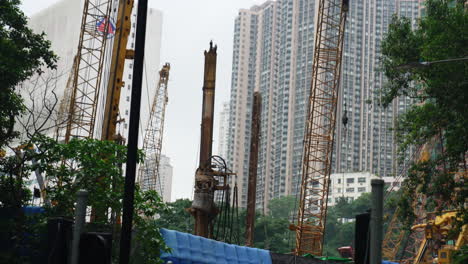 Sitio-De-Construcción-En-Movimiento-Tomado-Desde-Abajo-Con-Rascacielos-De-Hong-Kong-En-El-Fondo