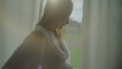 pensive woman in sunlight by window