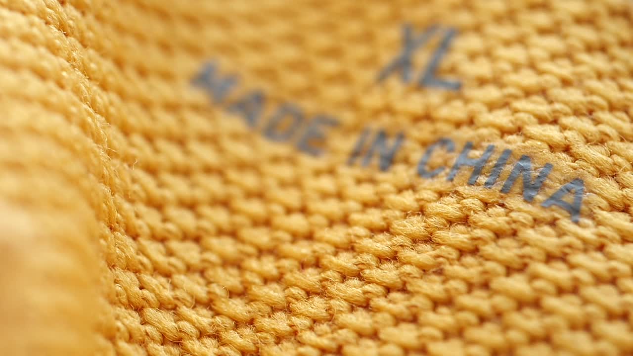 '중국에서 제조'하고 'xl'라고 적힌 옷 라벨의 클로즈업