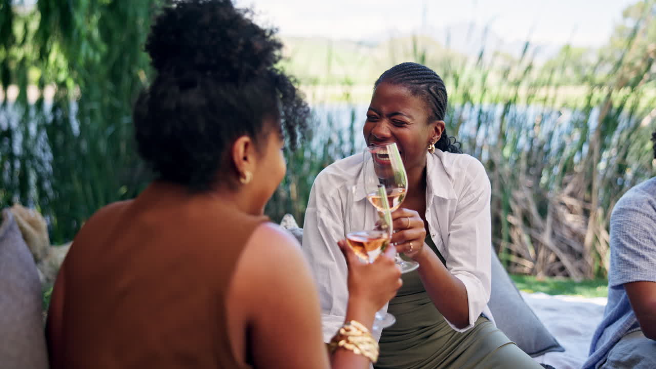 Happy Women Laughing and Toasting with Wine at an Outdoor Picnic