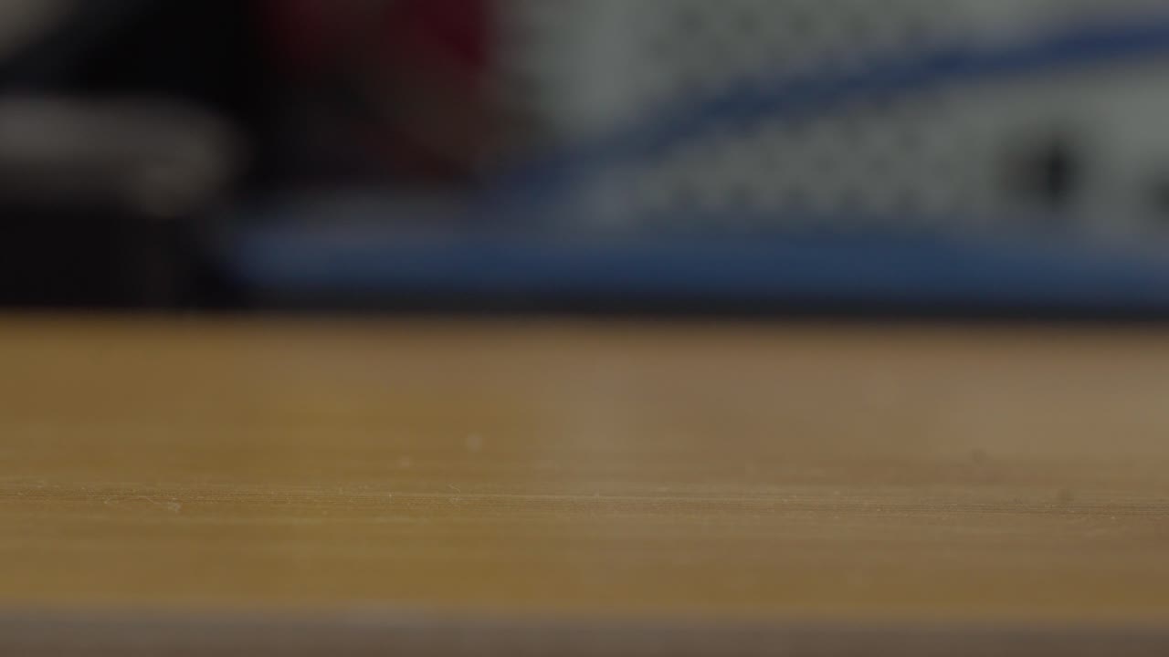 Close up kelereng kaca berwarna-warni yang tumpah dari tas jaring ke permukaan kayu