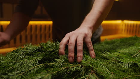 person arranging christmas fir branches