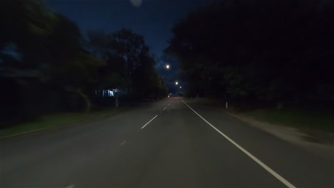 rear facing night driving point of view pov for interior car scene green screen replacement - quiet tree-lined backroads with warehouses and occasional passing trucks