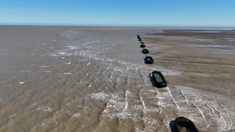 row of barges on river blackwater essex uk used for ww2 target practice