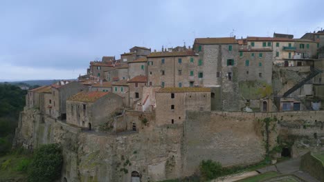 Aerial-view-of-an-Italian-medieval-town-at-first-light-on-an-autumn-day,-medium-shot