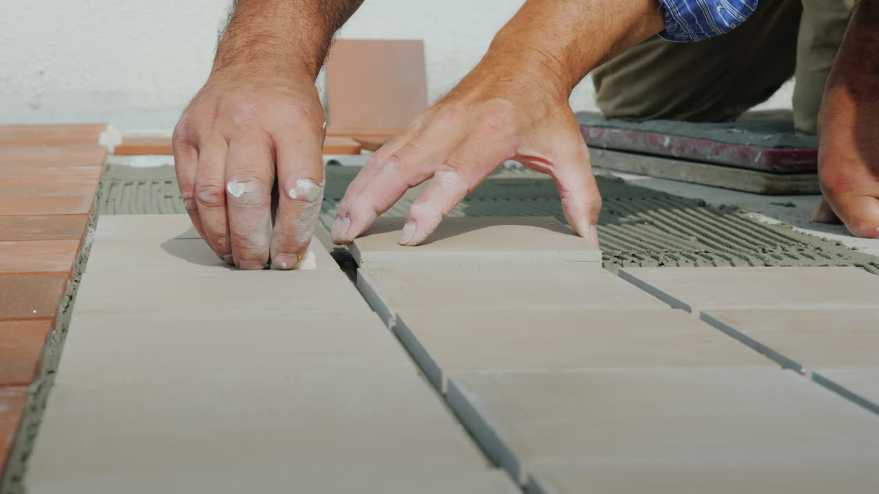 Master Lays Ceramic Tiles On The Floor