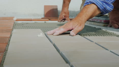 master lays ceramic tiles on the floor