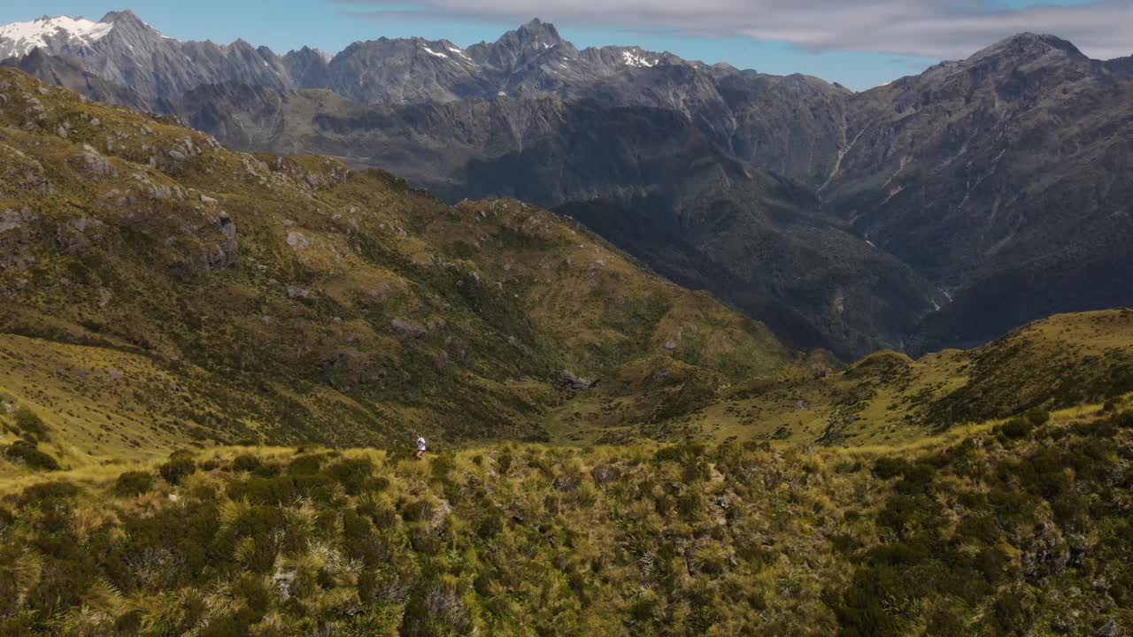 joven viajero caminando por la cresta de la montaña rastreo aéreo