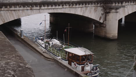 boat moored on riverside in seine river by the pont neuf in paris, france