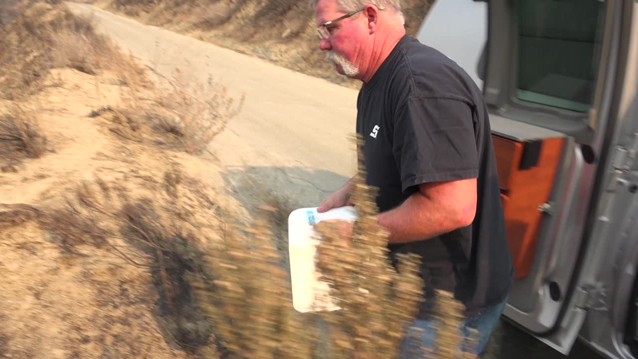 한 남자가 2017년 토마스 산불로 인해 피해를 입은 야생 동물에게 먹이를 주기 위해 불탄 협곡에 소금 덩어리를 굴려 넣습니다.